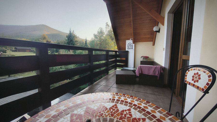 Krytý balkon s mozaikovým stolkem a výhledem na Radhošť